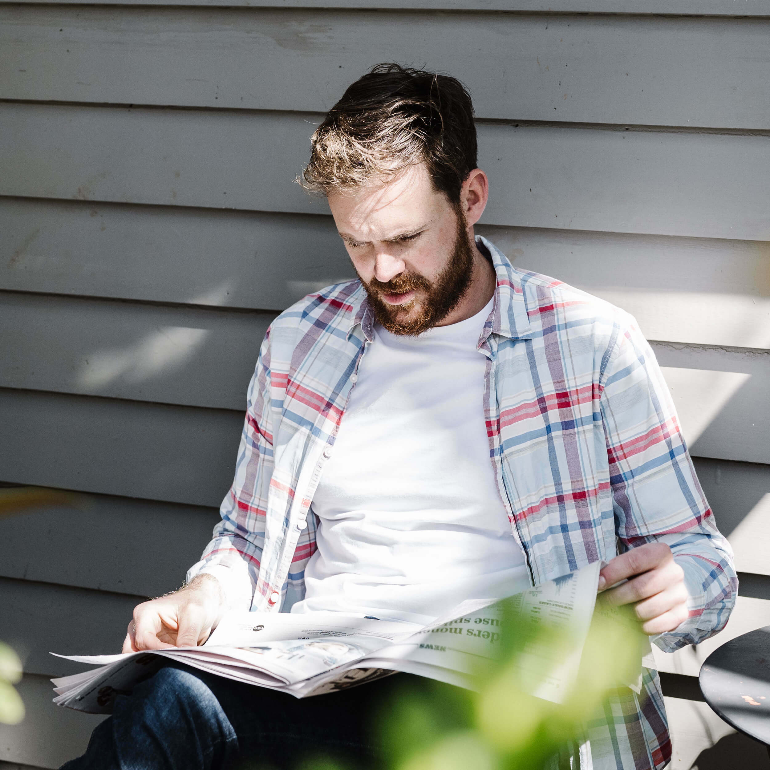 A man reads the newspaper outside as he assesses his fertility.