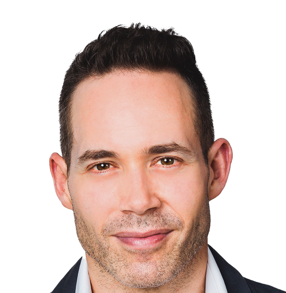 A man smiles into the camera. He is Caucasian with brown hair and hazel coloured eyes. He has a sharp jawline and is wearing a black blazer and a white shirt. He is an obstetrician and gynaecologist and fertility specialist Monash IVF.